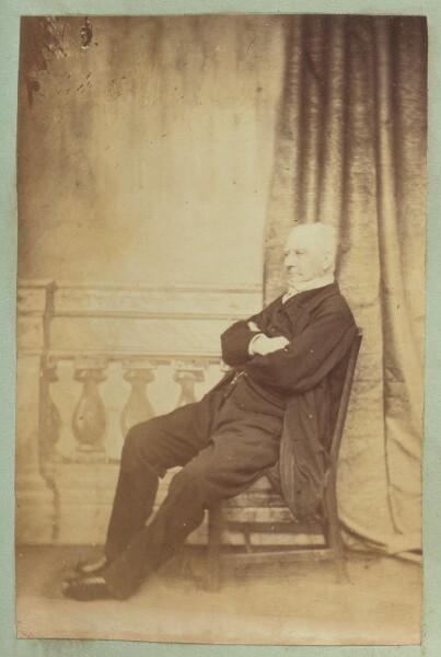 Unknown, [Portrait of man with studio background of baluster and curtain]
