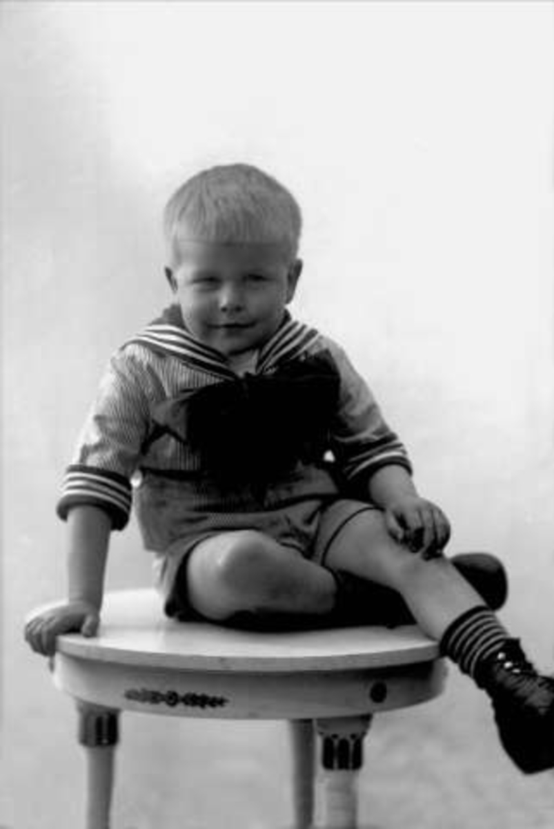 Gustav Borgen, Portrett, gutt i matrosdress sitter på et bord. Eivind Hoff.