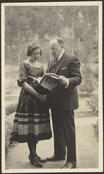 Louis Fleckenstein, [Man and Woman Standing Outside with Magazine]