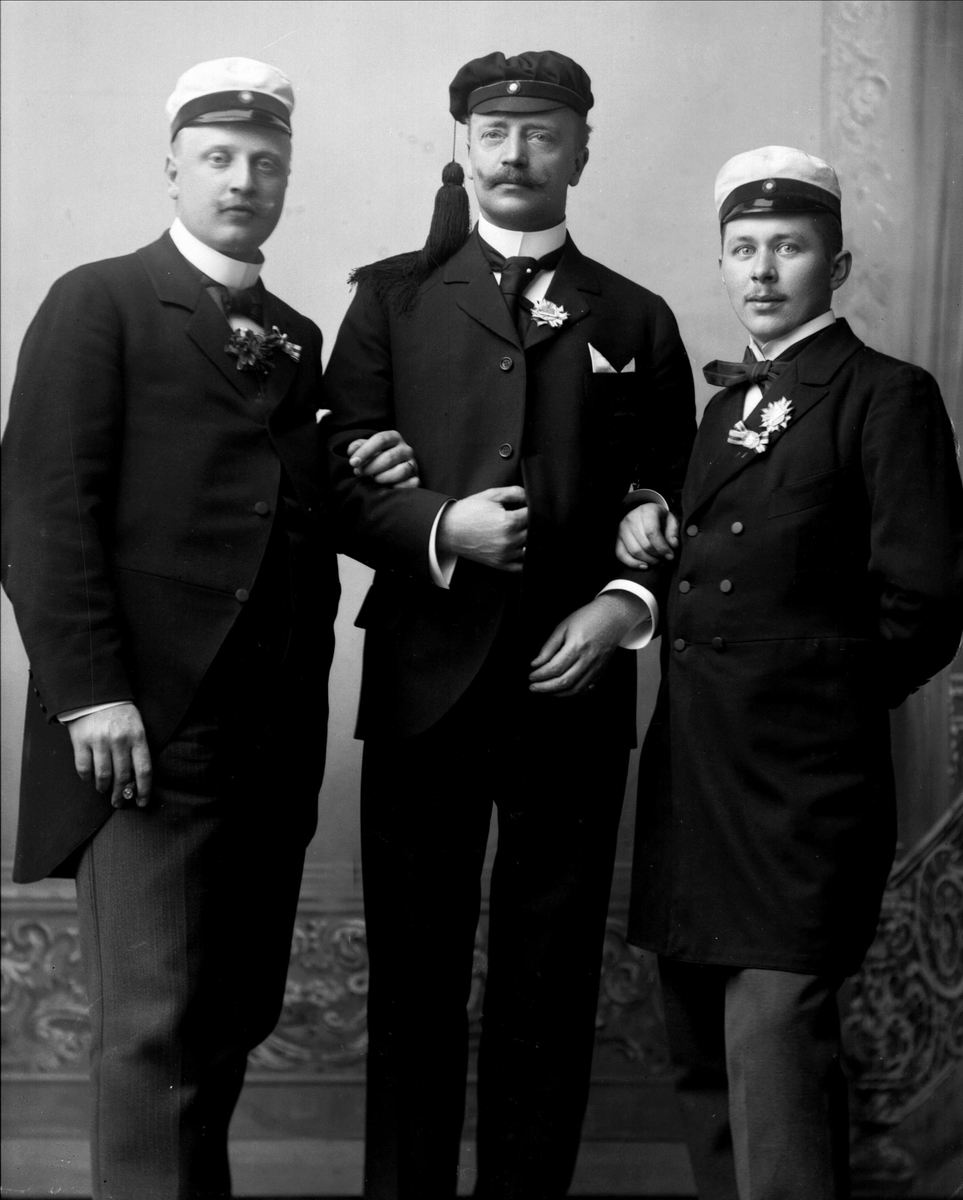 Gustav Borgen, Gruppeportrett, tre menn arm i arm, med lue. Studentlue, og to hvite luer.