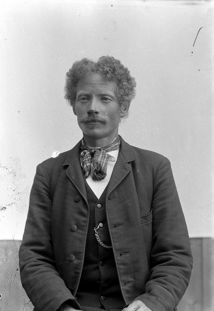 Jakob Jakobsen Engerdal, Mann m/bart, krøllet hår og et tørkle knyttet i halsen.