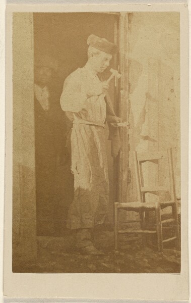 Unknown, [Unidentified man wearing a round cap, using a hammer]
