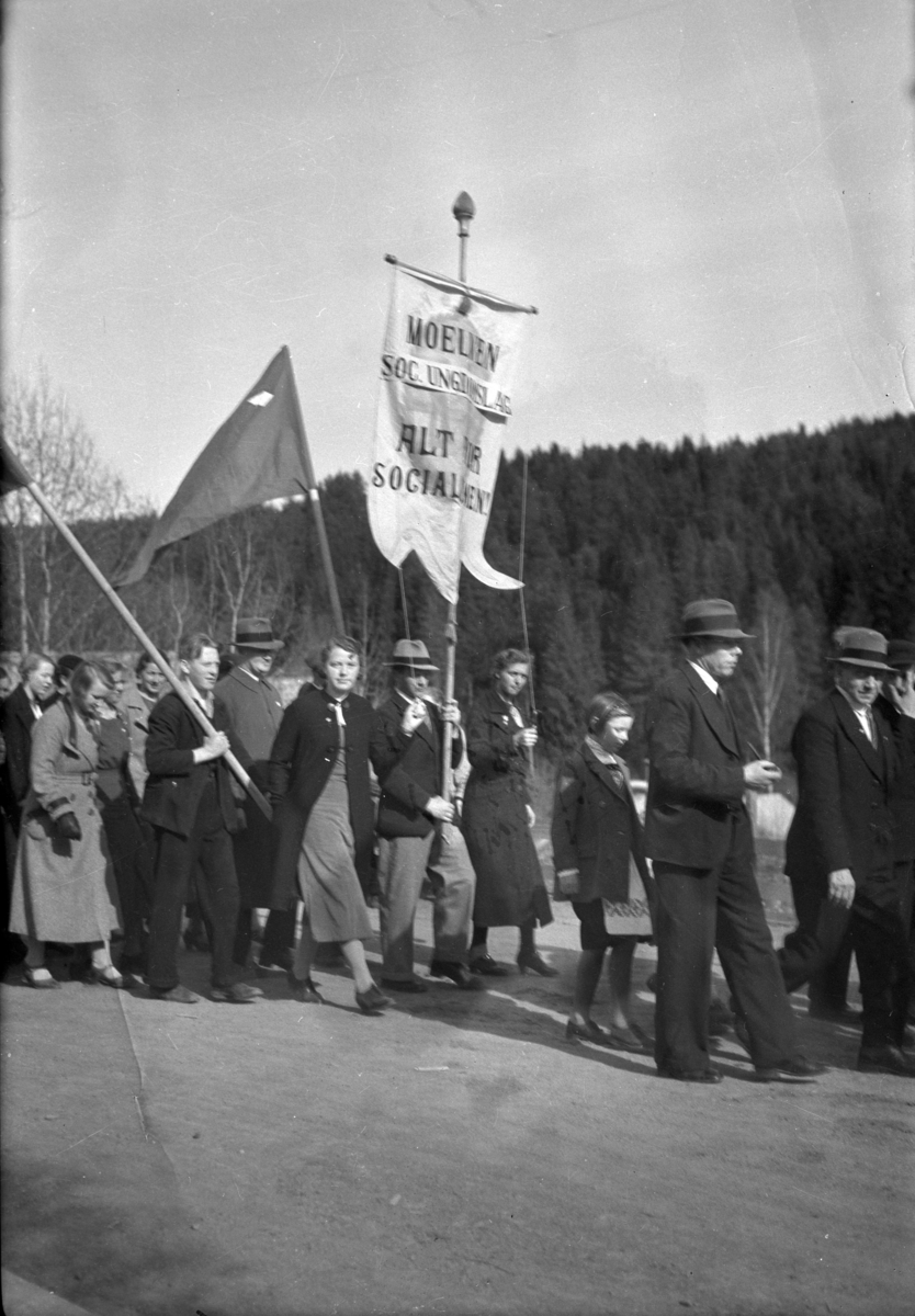 Håkon Prestkværn, 1. mai -toget i Moelv 1935-36. Fane Moelven Soc. Ungdomslag. "Alt for Socialismen" Kristian Fonstad under i hatt under fanen. Fag og arbeiderbevegelsen.
