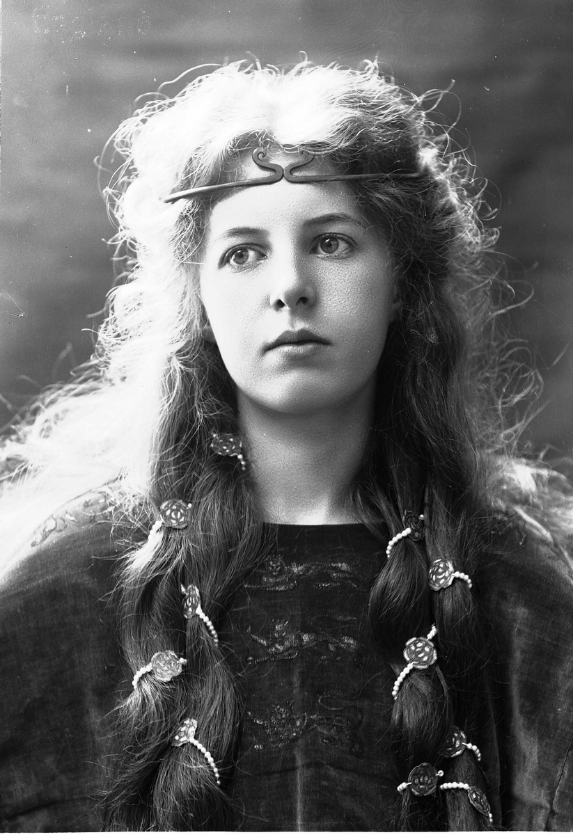 Solveig Lund, Brystportrett av kvinne i drakt med riksvåpen og hårsmykke.