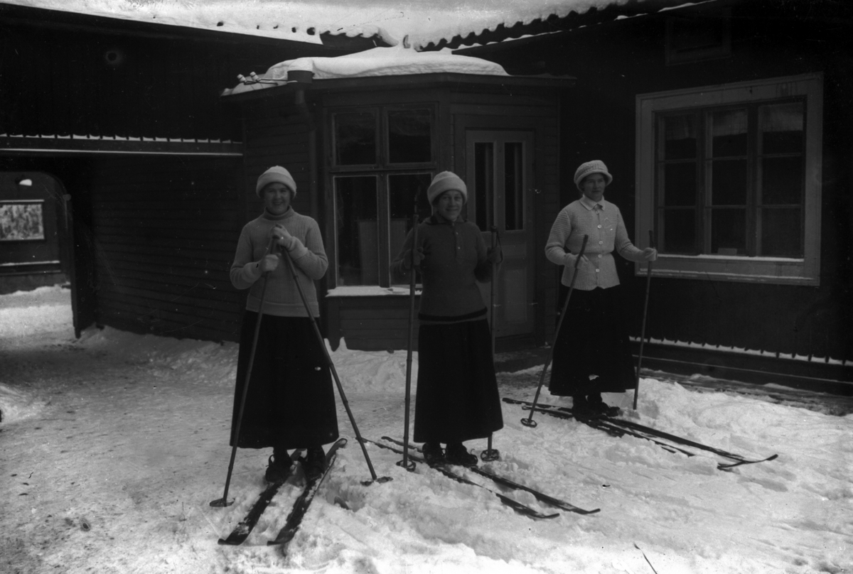 Ester Pettersson, Tre unga kvinnor på skidor. I mitten Ester Pettersson (givarens faster). I bakgrunden skrädderiet.