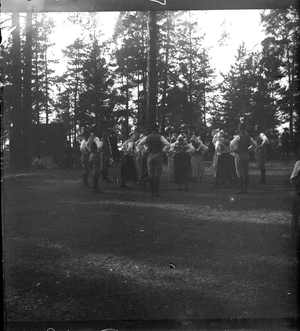 Unknown artist, Folk dance on a grass pitch among tall pines. Probably on the Boundary.