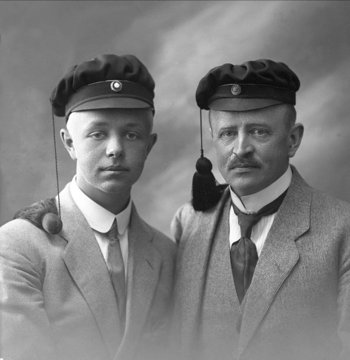 Gustav Borgen, Gruppeportrett, to menn med studentlue. Far og sønn (Knut Jenssen)).