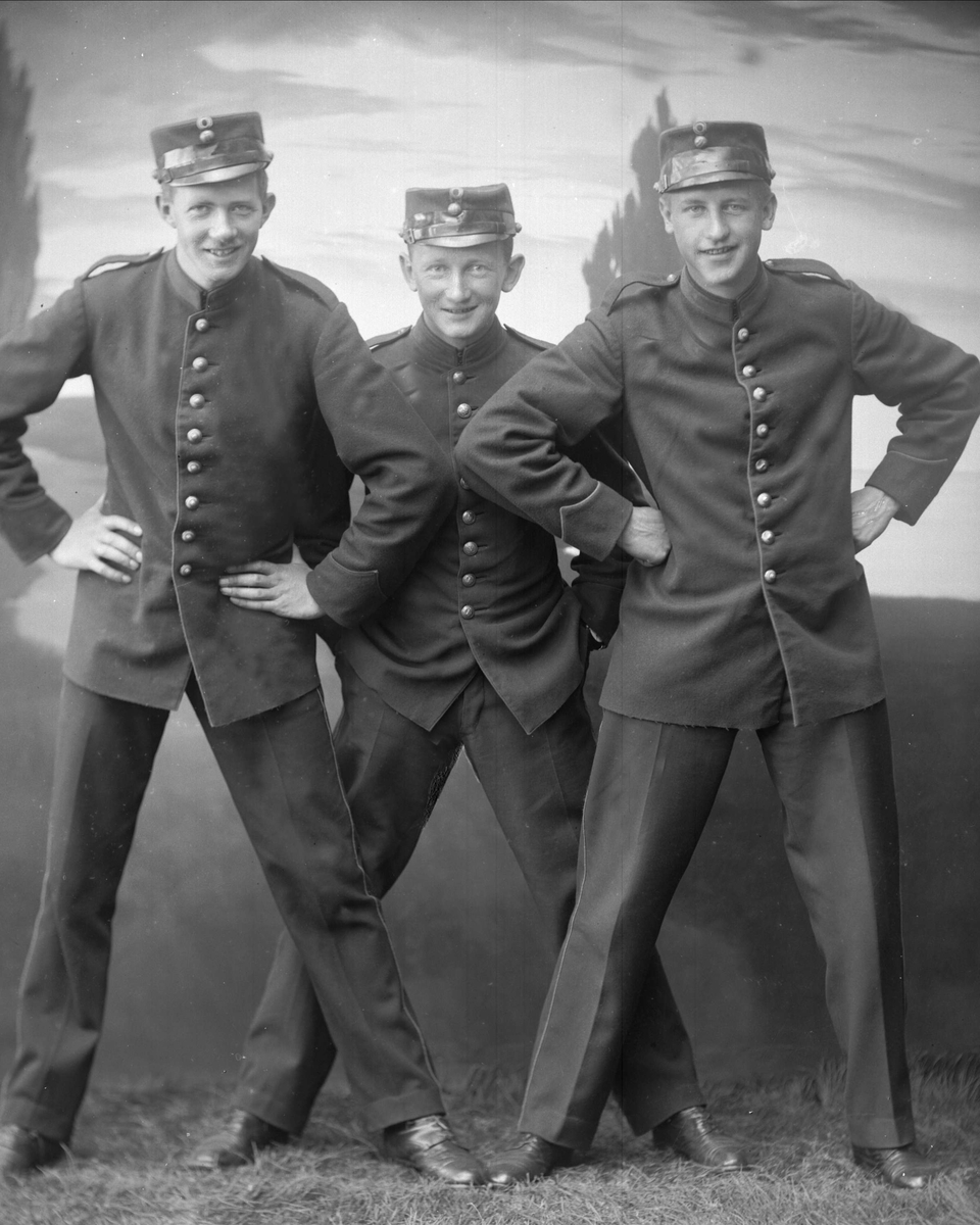 Gustav Borgen, Gruppe, tre soldater i uniform med hender i sidene eller lommene. Umilitær positur.