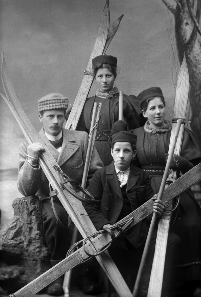 Gustav Borgen, Gruppeportrett, fire skiløpere hos fotografen, to herrer og to damer, med ski.