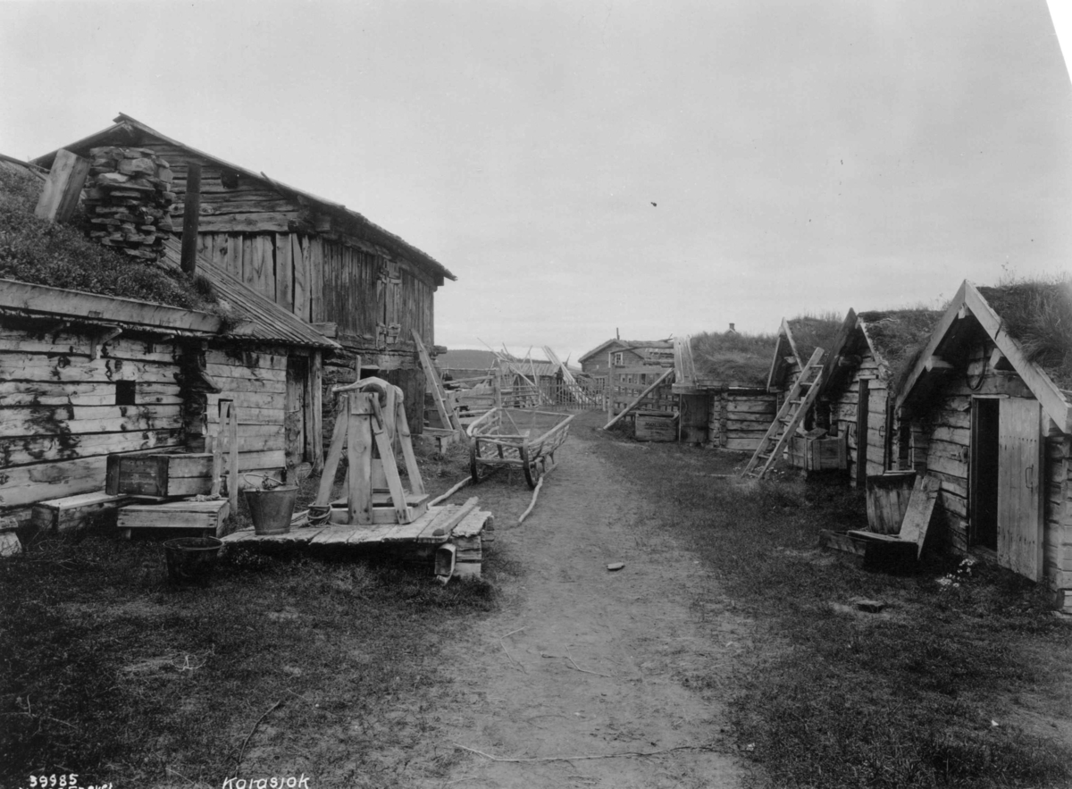 Anders Beer Wilse, To husrekker med vei i mellom. Husene har torvtak. Karasjok 1933.
