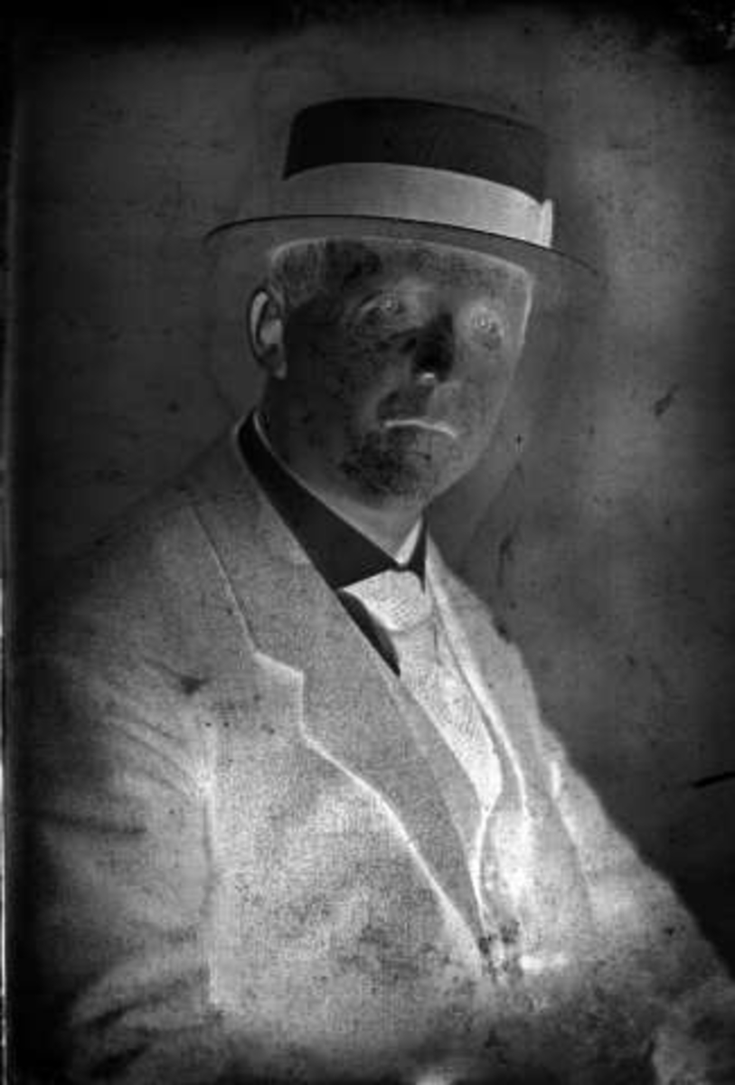 Gustav Borgen, Portrett, mann med dress og hatt. Robert Johnsen.