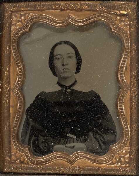 Unknown, [Young woman wearing wire-rimmed glassed seated]