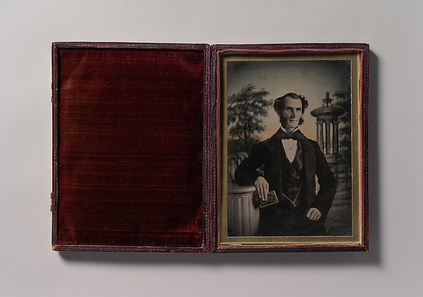 Unknown, [Man Holding Book, Standing Before a Painted Scenic Backdrop]