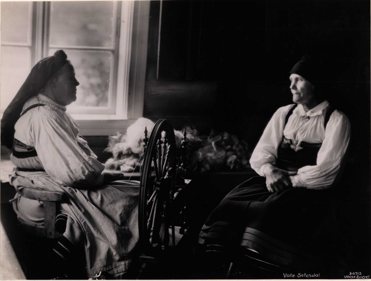 Anders Beer Wilse, To kvinner ved en rokk i en stue. Valle, Setesdal, Aust-Agder, antagelig 1929.