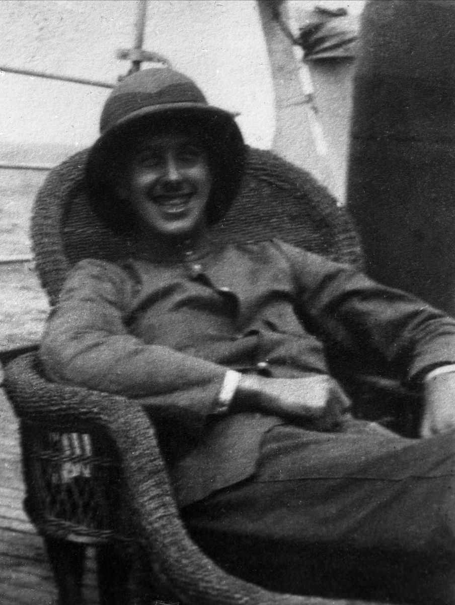Gustav Borgen, Avfotografering. Mann i kakiklær og tropehjelm i kurvstol på båtdekk.