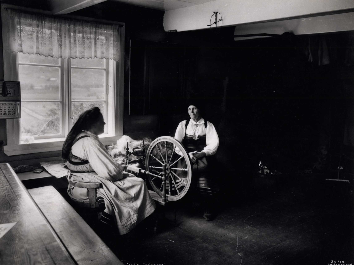 Anders Beer Wilse, To kvinner ved en rokkr i en stue. Valle, Setesdal, Aust-Agder, antagelig 1929.