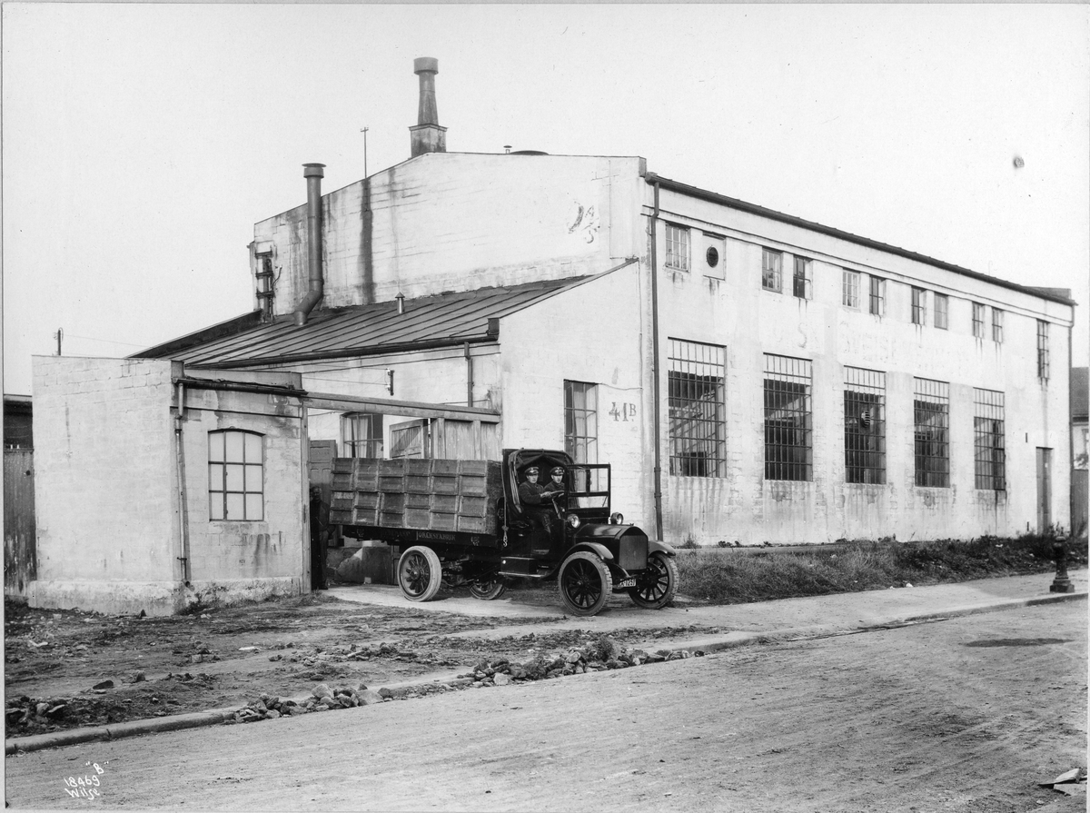 Anders Beer Wilse, Tiedemanns eskefabrikk på Bergensgate. En lastebil med kasser er på vei ut av fabrikken.