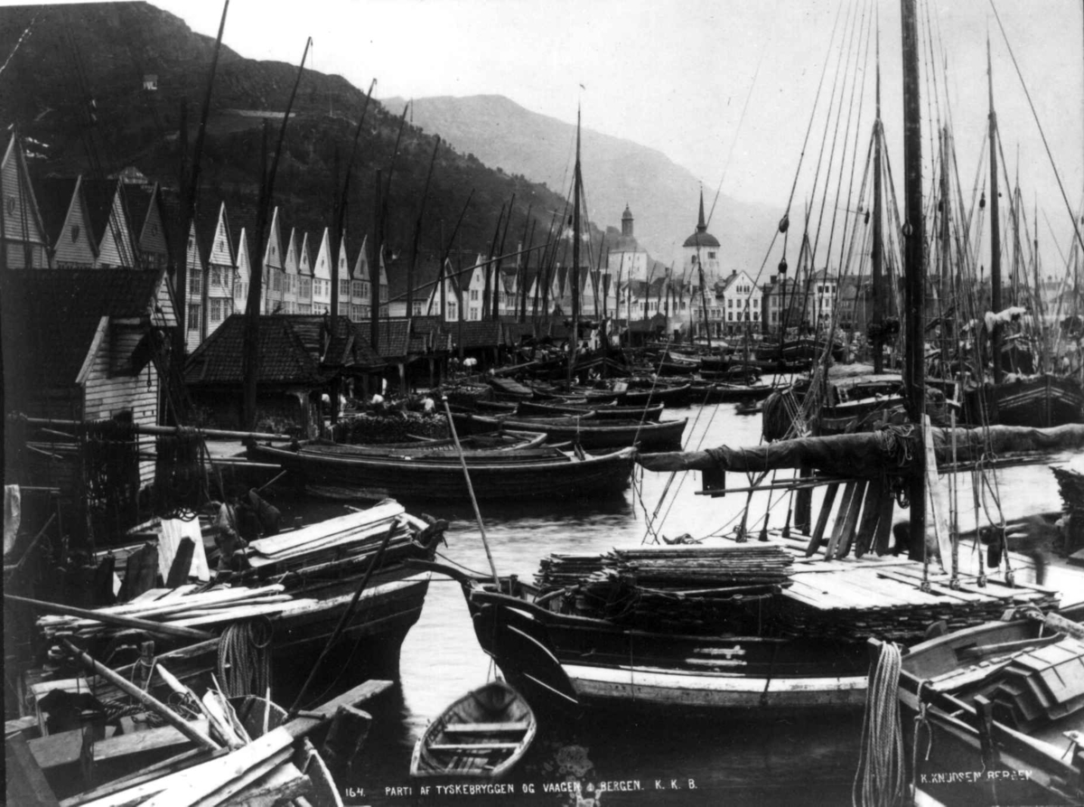 Knud Knudsen, Havneparti, Bergen, Hordaland. Havn full av båter, bebyggelse i rekke og kirke i bakgrunnen.