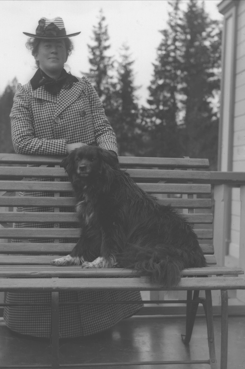 Gustav Borgen, Kvinne bak benk med hund på veranda.