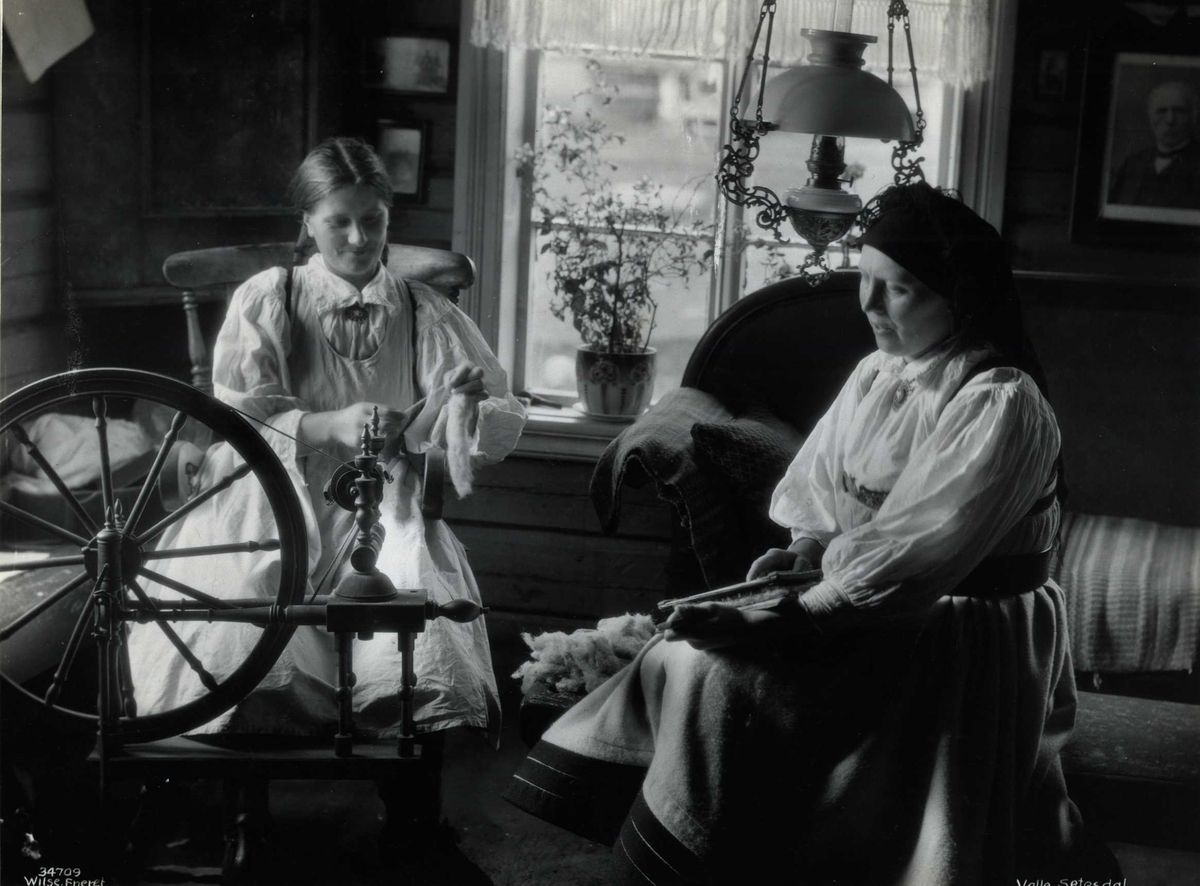 Anders Beer Wilse, To kvinner karder og spinner i en stue. Valle, Setesdal, Aust-Agder, antagelig 1929.
