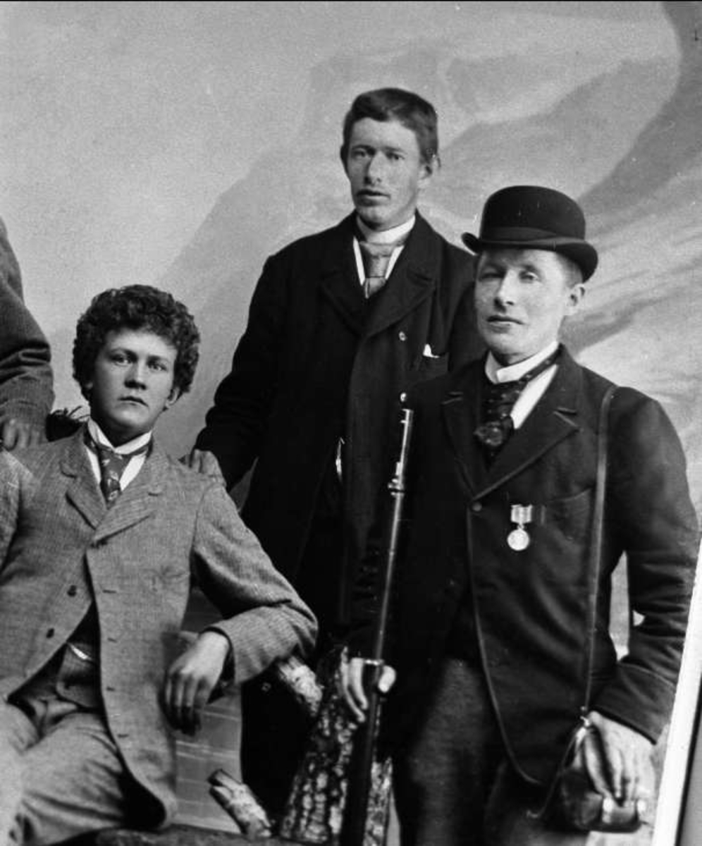 Gustav Borgen, Avfotografering. Gruppeportrett, tre yngre menn, en med gevær og medalje.