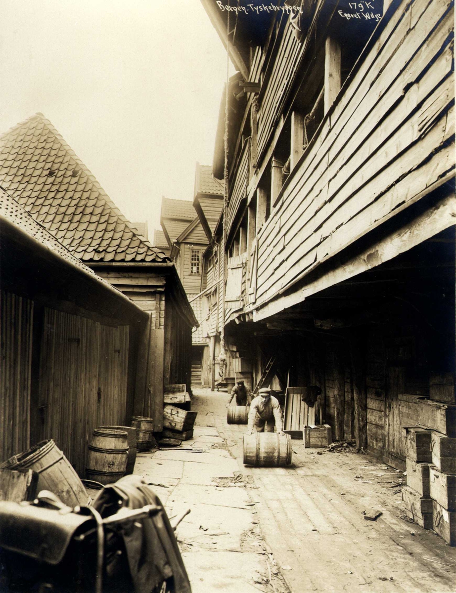 Anders Beer Wilse, Svendsgården, Tyskebryggen, Bergen, Hordaland. Menn triller tønner. Fotografert 1912.